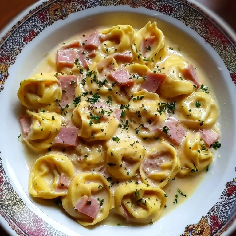 Cremige Tortellini mit Schinken und Käse auf einem Teller serviert
