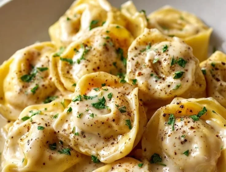 Cremige Knoblauch-Parmesan Tortellini auf einem Teller serviert