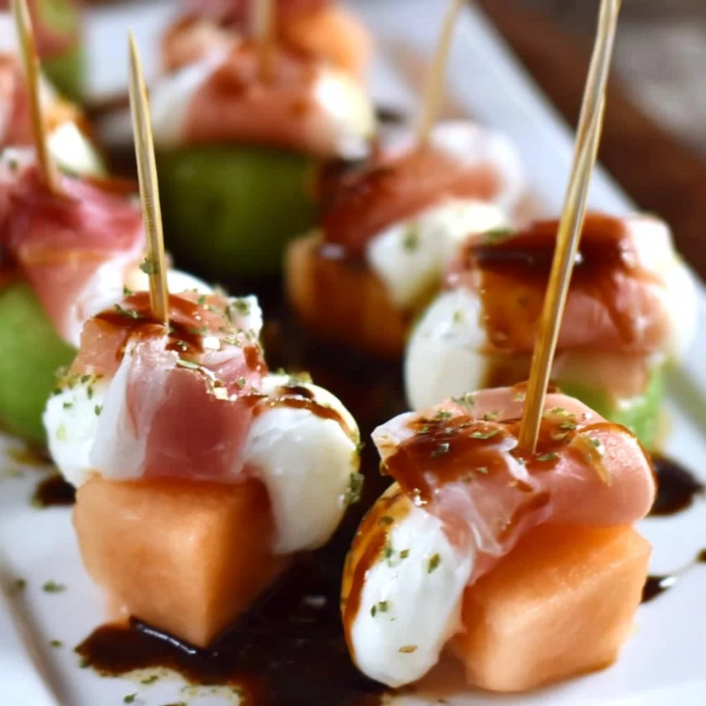 Melonen-Mozzarella-Schinken Fingerfood auf einem eleganten Party-Teller