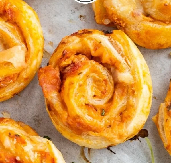 Leckere Pizzaschnecken frisch aus dem Ofen, garnished mit Käse und Kräutern